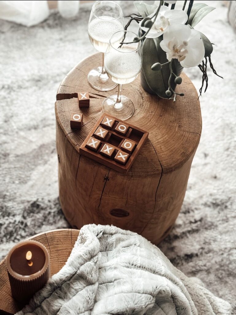 Détails de décoration, le cocon blanc, pour votre séjour à Metz. Deux verre de vin posé sur des rondins de bois. Ambiance cocooning.