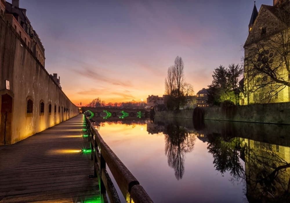Metz de nuit au bord de l’eau avec reflets lumineux ambiance romantique