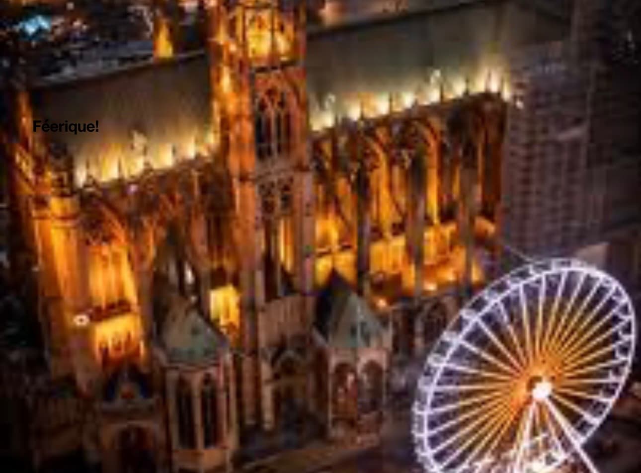 Vue aérienne plongeante de la cathédrale de Metz illuminée et de la grande roue éclairée pendant le marché de Noël